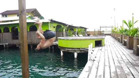 Young Man In Shorts Doing A Backflip Into The Water [Slow Motion] Stock Footage 89876272