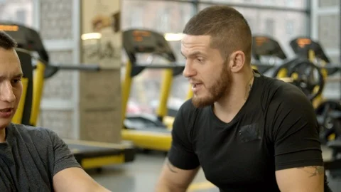 Young man shouted at by instructor while working out in gym Stock Footage 125533542