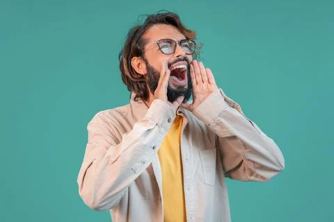 Young man shouting attention call announcing loudly yelling using hands. Male Stock Photos