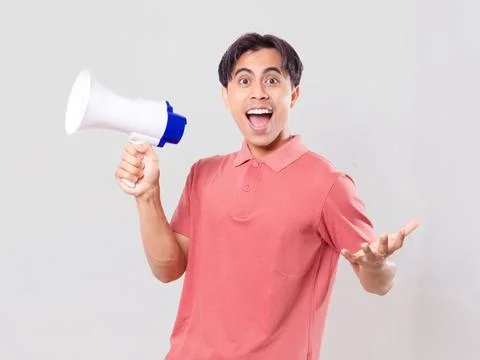 Young man shouting through a megaphone with one hand outstretched while sho.. Stock Photos