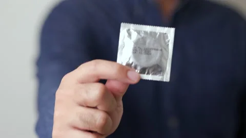 The young man showing the condom into camera. Campaign for safe sex. Stock Footage 161233080