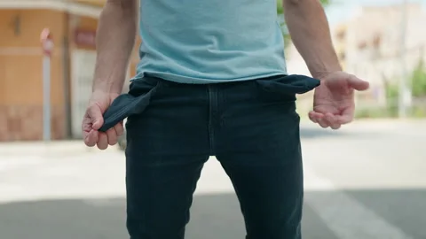 Young man showing empty pockets at street Stock Footage 197008811