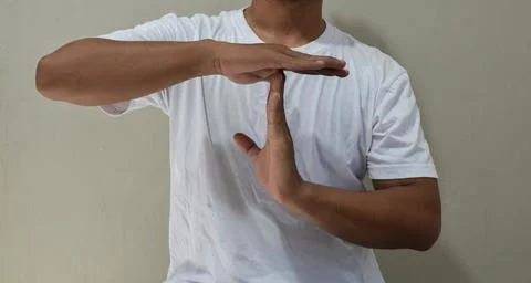 Young man showing a pause time out gesture with hands Stock Photos