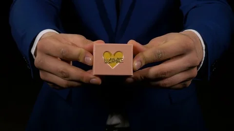 Young man showing a small gift box with love Stock Footage 74678500