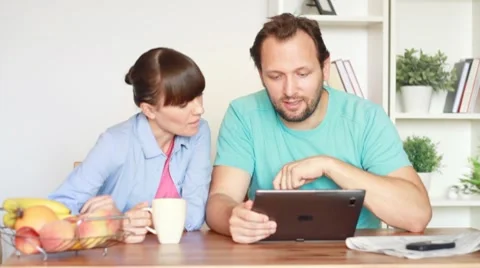 Young man showing something to his girlfriend on tablet computer Stock Footage 8608115