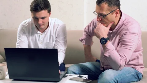 Young man showing something on his laptop Stock Footage 111295351