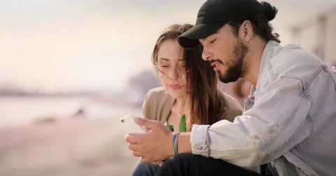 Young man showing something on the smartphone to attractive young woman Stock Footage 81197491