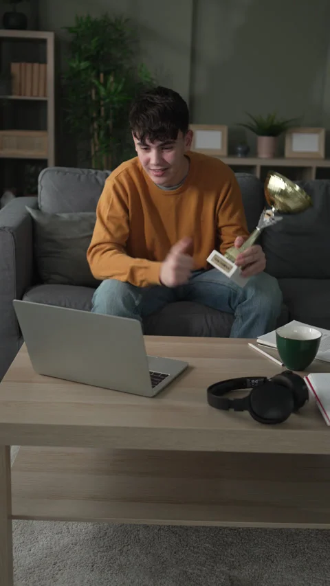 Young man showing off trophy during video call Stock Footage 328361392