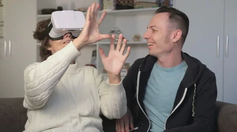Young man showing virtual reality glasses to an old woman. Elderly woman smiling Stock Footage 68646068