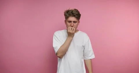 Young man shows different expressions with a pink background in a studio se.. Stockbeeldmateriaal 328246966