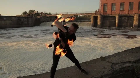 A young man shows a fire show against the backdrop of an old German Video stock 81511568