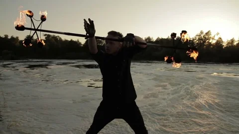 A young man shows a fire show against the backdrop of an Rriver. 스톡 동영상 81514276