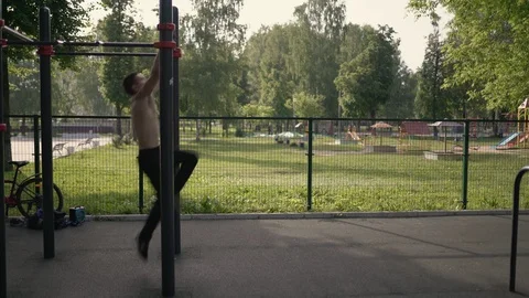 Young man shows gymnastic exercise with a jump on the horizontal bar Video stock 92312730