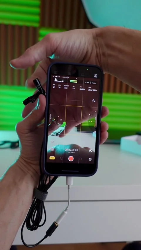 Young man shows how to shoot video on a smartphone with a microphone Stock Footage 240241869