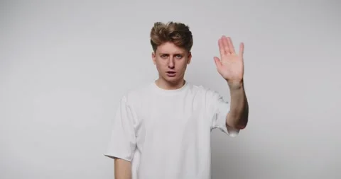 Young man shows stop gesture with displeased face. Young man posing against.. Stock Footage 313273677