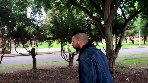 Young man from the side running in a forest of a park in the city Stock Footage 248307816