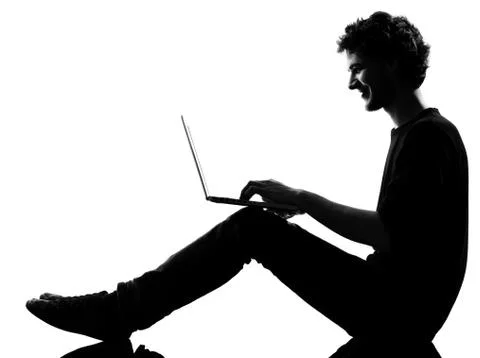 Young man silhouette sitting computing laptop Stock Photos