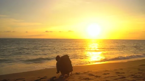 Young man in silhouettes having fun at sunset beach Stock Footage 163141821
