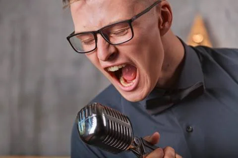 Young man singing with microphone Stock Photos