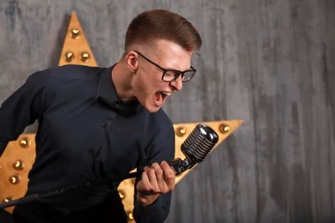 Young man singing with microphone Stock Photos