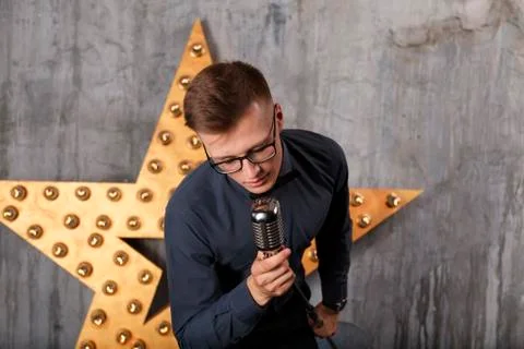 Young man singing with microphone Stock Photos