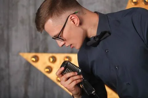 Young man singing with microphone Foto stock