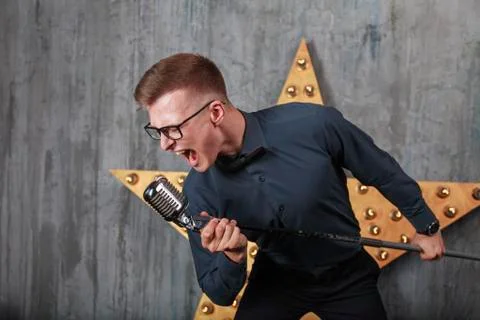 Young man singing with microphone Stock Photos