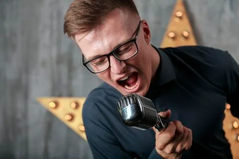 Young man singing with microphone Stock Photos