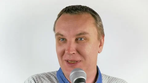 Young man singing into a microphone while looking into the camera.Young man in Stock Footage 149217827