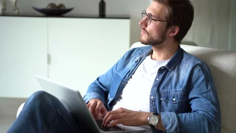 Young man sit in armchair use laptop, working distantly using wireless tech Stock Footage 155331422