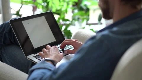 Young man sit in armchair use laptop, working distantly using wireless tech Stock Footage 155331797
