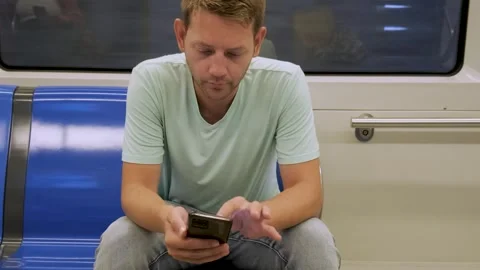 Young man sit in empty metro train in subway and using smartphone for online Stock-Footage 286358290