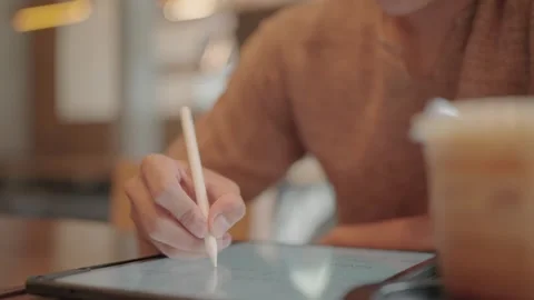 A young man sits and drinks coffee to find information on the internet. Stock Footage 251974025