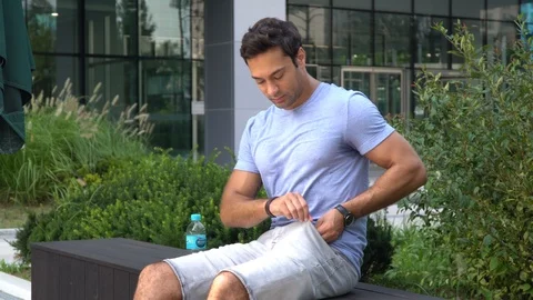 A young man sits on a bench in front of the office, takes the box with Stock Footage 115040701