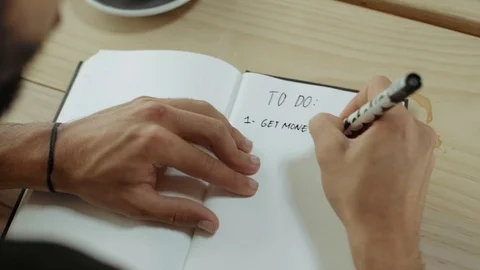 Young man sits in cafe and writes plan Video stock 76048826