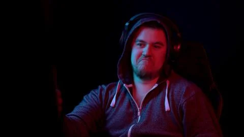 A young man sits at a computer and expresses respect. Emotions on his face Stock Photos