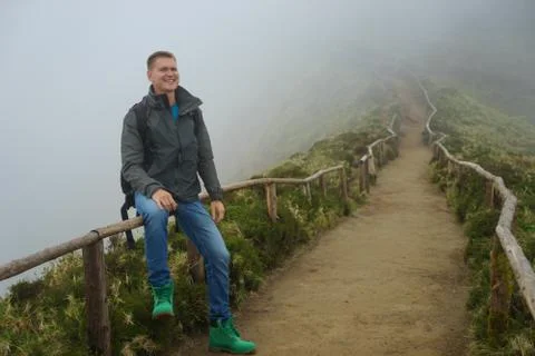 A young man sits at the edge of a path Stock Photos