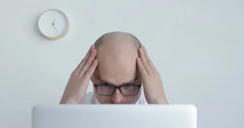 Young man sits in front of a laptop and thinks. Close-up. Stock Footage 154015236