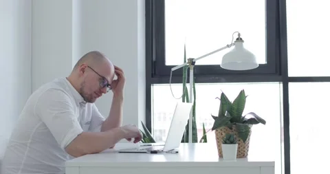 Young man sits in front of a laptop and thinks. Side view. Stock Footage 154032958