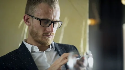 Young man sits with mobile device at the table in the cafe. Stock Footage 78937647