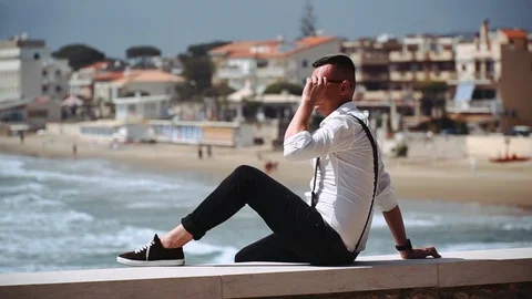 	A young man sits on a pier. Stock Footage 108311375