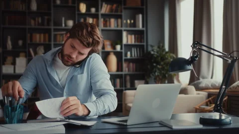 Young man sits at table with laptop in home office Stock Footage 260923903