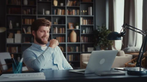 Young man sits at table with laptop in home office Stock Footage 260935038