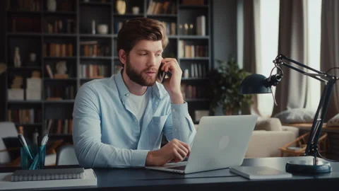 Young man sits at table with laptop in home office Stock Footage 260938950