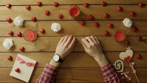Young man sits by table with luxury watch on his hand and waits, top view Stock Footage 87980466