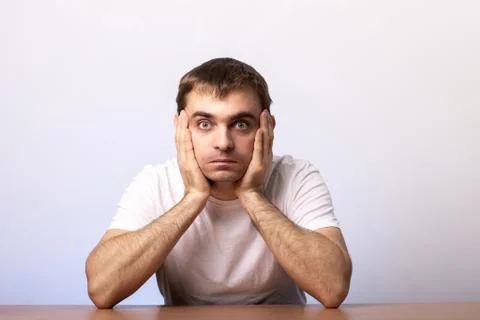 A young man sits at a table Stock Photos