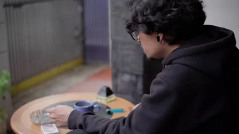 Young Man Sitting Alone with Coffee and Cigarette Indoors – Melancholic Mood Stock Footage 307286129