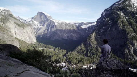 Young Man Sitting and looking at Yosemite Valley. Stock Footage 62603043