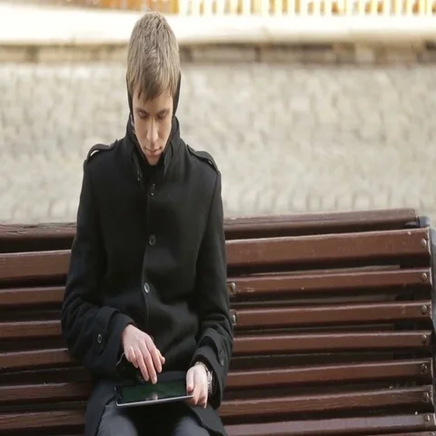Young man sitting and typing on the tablet Stock Footage 69622675