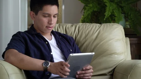 Young man sitting in armchair using digital tablet. 動画素材 88041103